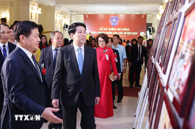 President Luong Cuong tittar på fotoutställningen om 80 år av vietnamesiska jurister. (Foto: Lam Khanh/VNA) ttxvn-chu-tich-nuoc-ngay-truyen-thong-luat-su-2.jpg