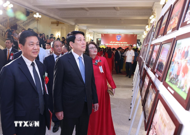 President Luong Cuong tittar på fotoutställningen om 80 år av vietnamesiska jurister. (Foto: Lam Khanh/VNA) ttxvn-chu-tich-nuoc-ngay-truyen-thong-luat-su-3.jpg