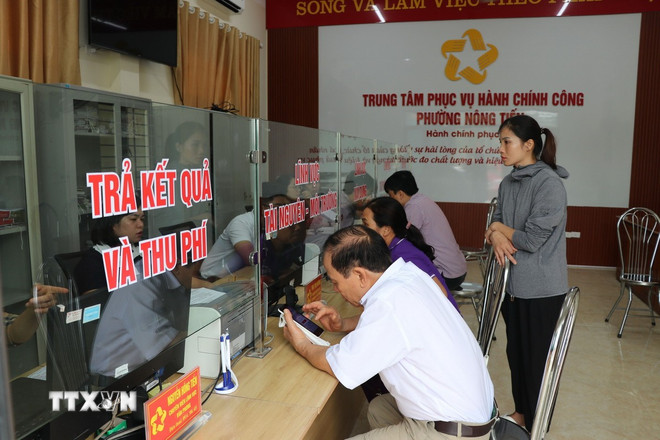 Folk kommer for å jobbe ved det offentlige administrasjonssenteret i Nong Tien-distriktet i Tuyen Quang-provinsen. (Foto: Hoang Hai/VNA) ttxvn-thu-tuc-hanh-chinh-hanh-chinh-cong-1.jpg