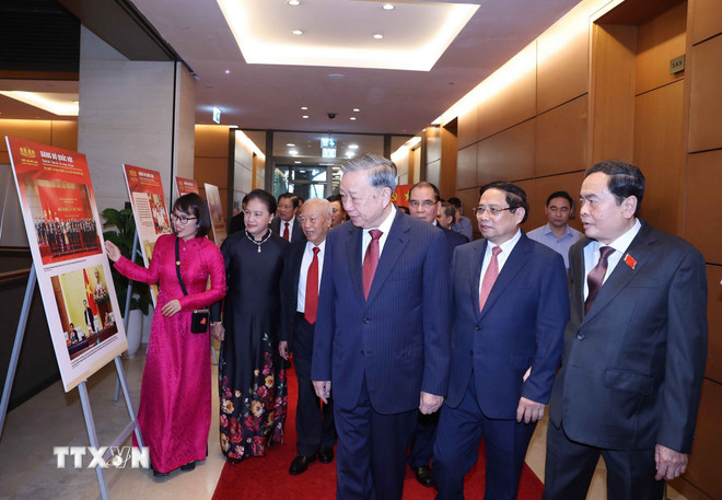 Generalsekretär To Lam sowie führende und ehemalige Partei- und Staatsführer betrachten die Fotoausstellung. (Foto: Thong Nhat/VNA) ttxvn-tong-bi-thu-dang-bo-quoc-hoi-1.jpg