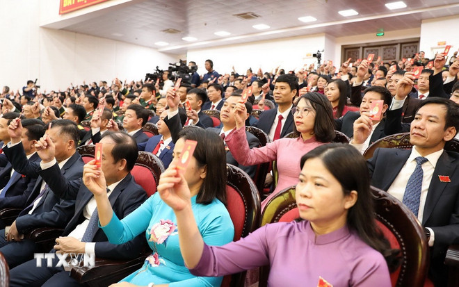 Delegații au votat pentru aprobarea proiectului de Rezoluție al Congresului Partidului Provincial Ninh Binh pentru mandatul 2025-2030. (Foto: Duc Phuong/VNA) ttxvn-nghi-quyet-dai-hoi.jpg