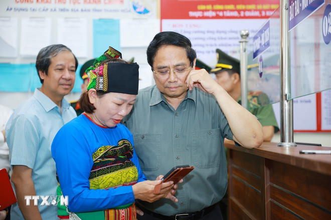 Başbakan Pham Minh Chinh, Thanh Hoa eyaletine bağlı Bat Mot komünündeki Kamu Yönetimi Hizmet Merkezi'nde işlem yaptırmak için gelen insanları ziyaret ediyor. (Fotoğraf: Duong Giang/VNA) ttxvn-thu-tuong-kiem-tra-tinh-hinh-hoat-dong-cua-trung-tam-phuc-vu-hanh-chinh-cong-xa-bat-mot-1.jpg