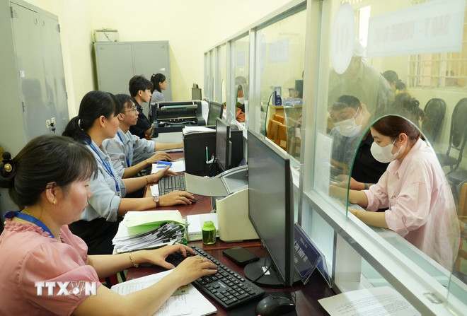 Officials and civil servants in Thai My commune (Ho Chi Minh City) often have to work overtime to handle administrative documents for people. (Photo: Huu Duyen/VNA) ttxvn-chinh-quyen-dia-phuong-2-cap-1.jpg