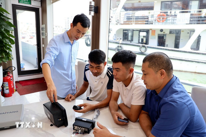 Officers of the Hon Gai Coastal Information Station instruct on the use of safety equipment (AIS, VHF). (Photo: Duc Hieu/VNA) ttxvn-tau-du-lich-ha-long-3.jpg
