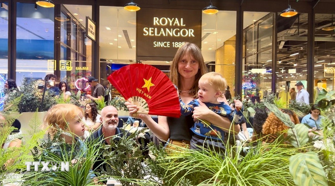 Das Publikum posiert gerne mit einem handgefertigten Fächer mit der vietnamesischen Flagge. (Foto: VNA) ttxvn-van-hoa-viet-nam-3.jpg