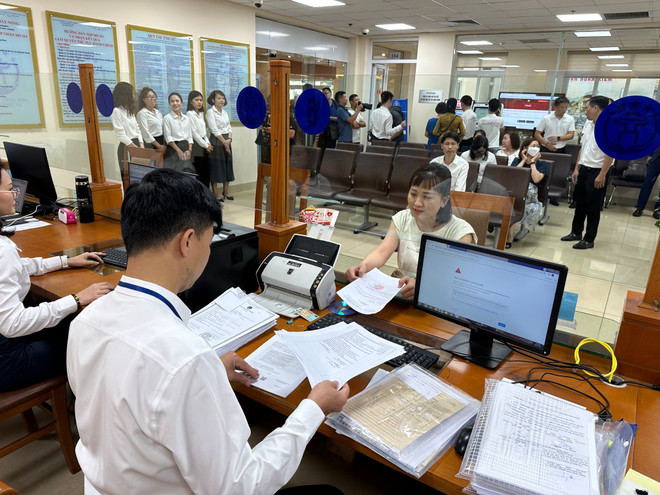 Cán bộ Trung tâm Phục vụ hành chính công Hà Nội tiếp nhận các thủ tục hành chính. (Ảnh: Xuân Quảng/Vietnam+)