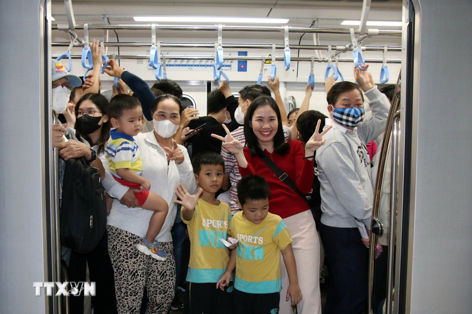 Hành khách tươi vui khi lên tàu metro số 1. (Ảnh: Tiến Lực/TTXVN)
