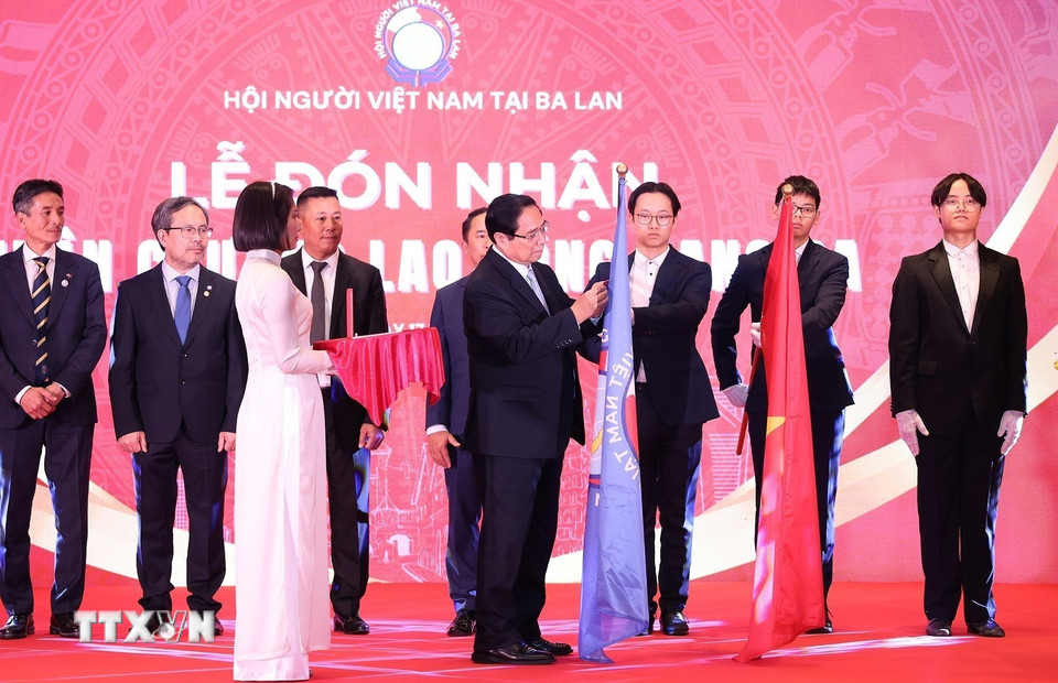 Thủ tướng Phạm Minh Chính gắn Huân chương Lao động hạng Ba tặng Hội người Việt Nam tại Ba Lan. (Ảnh: Dương Giang/TTXVN)