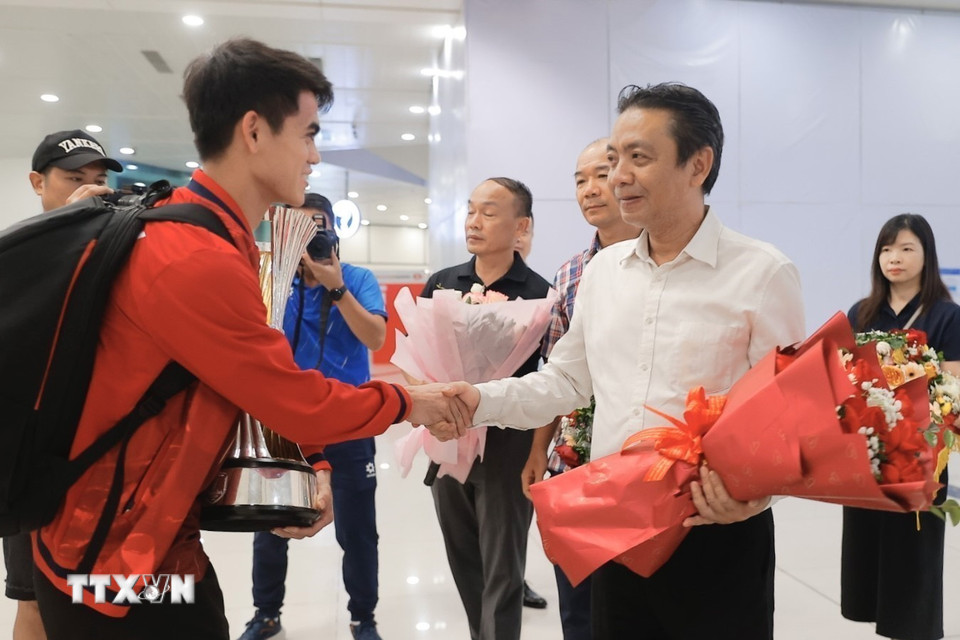 Thứ trưởng Bộ Văn hóa, Thể thao và Du lịch Hoàng Đạo Cương tặng hoa chúc mừng thầy trò HLV Kim Sang Sik. (Ảnh: Minh Quyết/TTXVN)