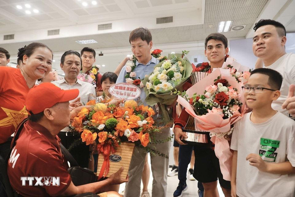 Người hâm mộ tặng hoa thầy trò HLV Kim Sang Sik. (Ảnh: Minh Quyết/TTXVN)