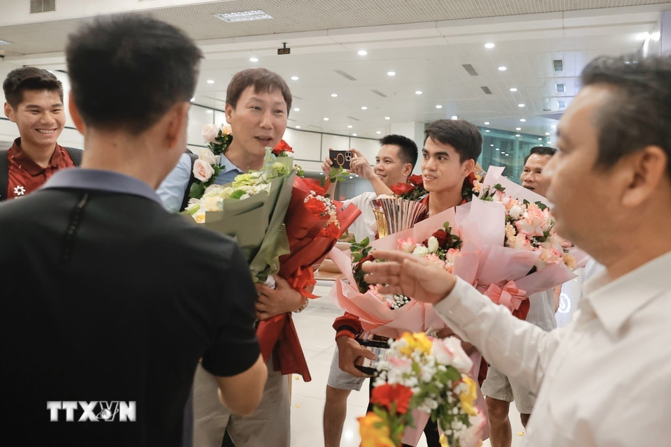Người hâm mộ đón thầy trò HLV Kim Sang Sik về đến sân bay quốc tế Nội Bài. (Ảnh: Minh Quyết/TTXVN)