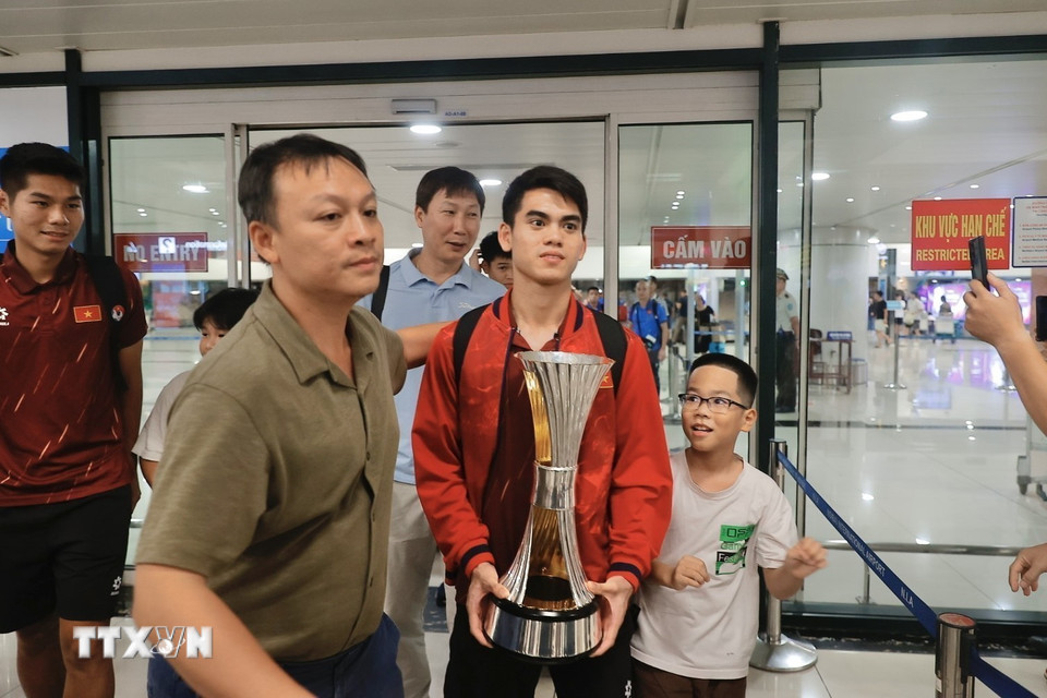 Thầy trò HLV Kim Sang Sik về đến sân bay quốc tế Nội Bài. (Ảnh: Minh Quyết/TTXVN)