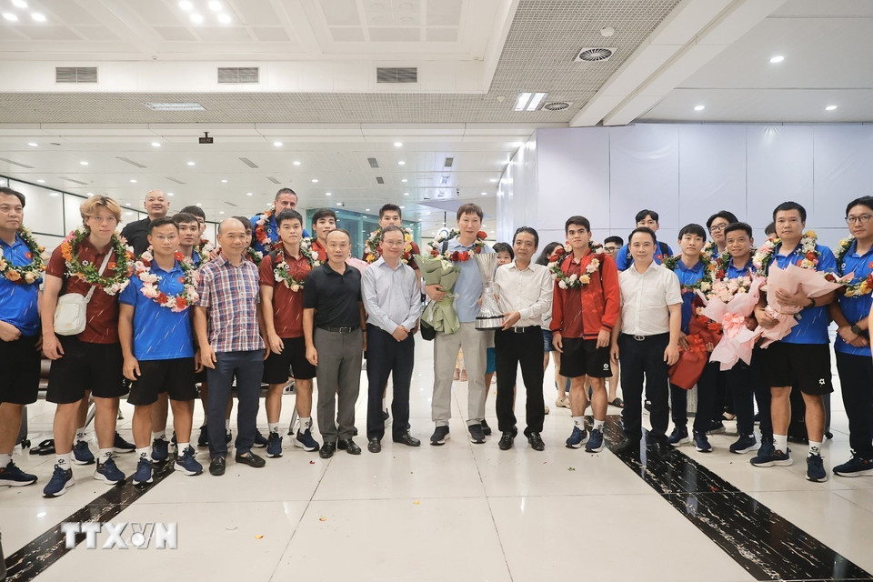 Thứ trưởng Bộ Văn hóa, Thể thao và Du lịch Hoàng Đạo Cương tặng hoa chúc mừng thầy trò HLV Kim Sang Sik. (Ảnh: Minh Quyết/TTXVN)