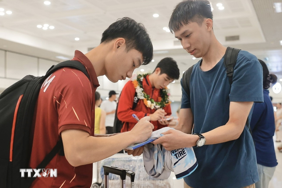 Cầu thủ ký tặng người hâm mộ. (Ảnh: Minh Quyết/TTXVN)