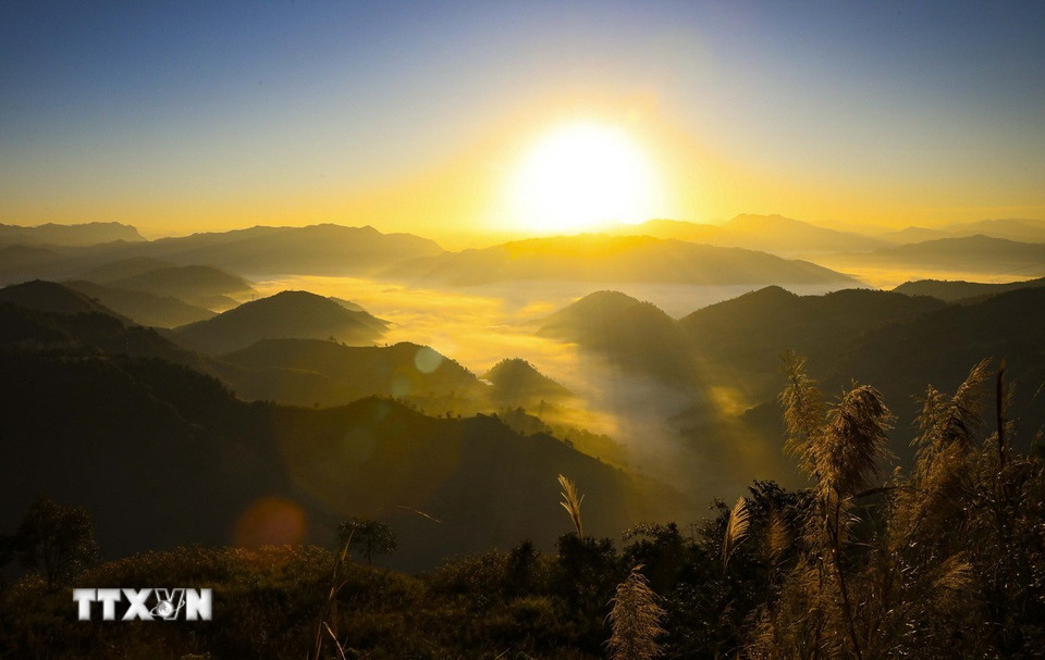 Zonnelicht filtert door de wolken die tussen de heuvels drijven. (Foto: Xuan Tu/VNA)