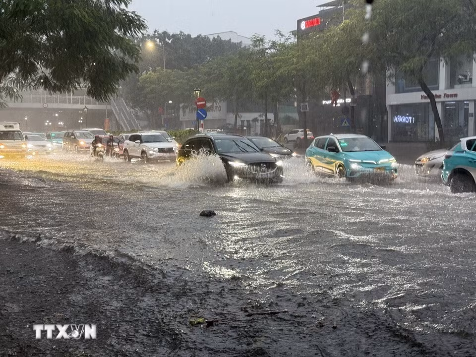 Trên tuyến phố Nguyễn Văn Cừ, Long Biên ngập úng diện rộng gây ảnh hưởng đến các phương tiện tham gia giao thông. (Ảnh: An Đăng/TTXVN)