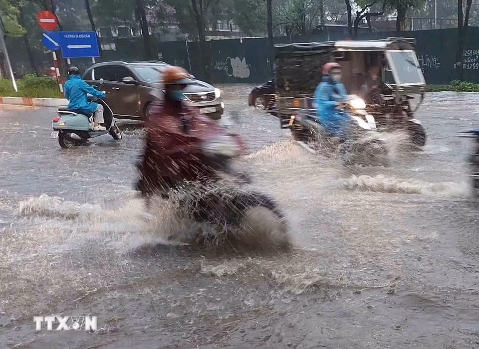 Chỉ sau vài phút mưa, tuyến phố Đào Tấn đã ngập úng diện rộng. (Ảnh: Văn Điệp/TTXVN)