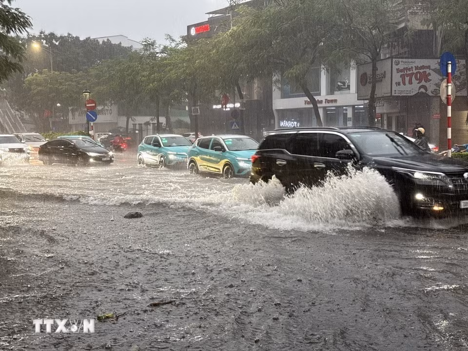 Chỉ sau vài phút mưa tuyến phố Nguyễn Văn Cừ, Long Biên đã ngập úng diện rộng gây ảnh hưởng đến các phương tiện tham gia giao thông. (Ảnh: An Đăng/TTXVN)