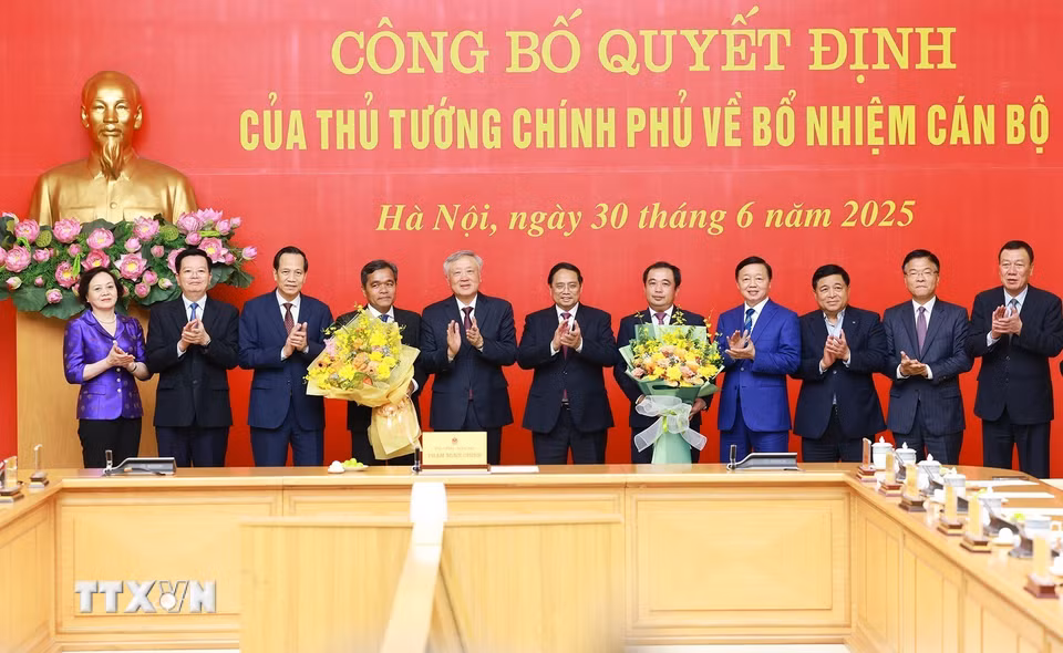 Thủ tướng Phạm Minh Chính và các Phó Thủ tướng tặng hoa chúc mừng đồng chí Trần Đức Thắng và đồng chí Hồ Văn Niên. (Ảnh: Dương Giang/TTXVN)