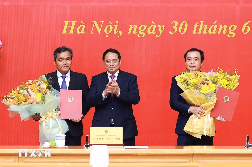 Thủ tướng Phạm Minh Chính trao quyết định và tặng hoa chúc mừng đồng chí Trần Đức Thắng, Phó Tổng Thanh tra Thường trực Thanh tra Chính phủ và đồng chí Hồ Văn Niên, Thứ trưởng Thường trực Bộ Dân tộc và Tôn giáo. (Ảnh: Dương Giang/TTXVN)