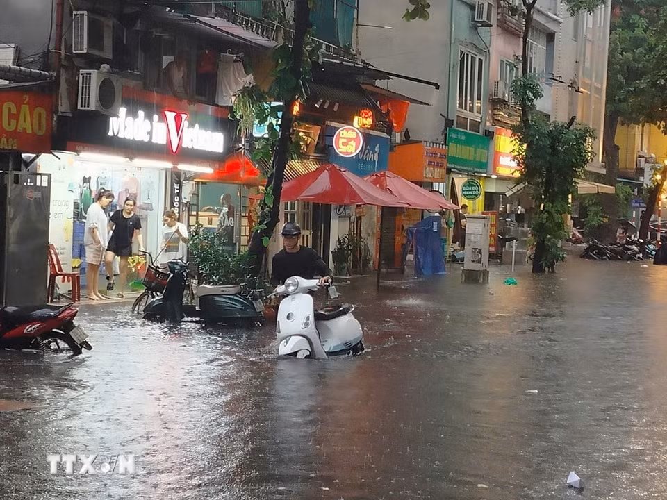 Nước dâng cao ảnh hưởng đến cuộc sống của nhiều hộ dân trên phố Trần Quốc Toản. (Ảnh: Hoàng Hiếu/TTXVN)
