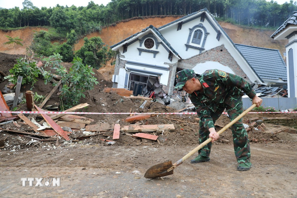 Lực lượng Bộ đội thu dọn đống đổ nát nhằm đảm bảo giao thông. (Ảnh: Tuấn Anh/TTXVN)