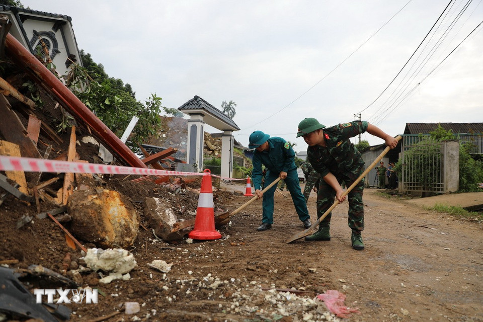 Lực lượng Bộ đội thu dọn đống đổ nát nhằm đảm bảo giao thông. (Ảnh: Tuấn Anh/TTXVN)