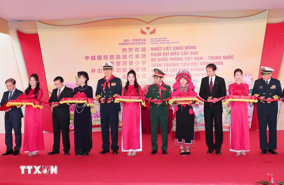 Đại tướng, Bộ trưởng Quốc phòng Phan Văn Giang, Thượng tướng, Bộ trưởng Quốc phòng Trung Quốc Đổng Quân và các đại biểu cắt băng khánh thành tòa nhà đa năng trong trường Tiểu học Đồng Đăng, thành phố Lạng Sơn. (Ảnh: Trọng Đức/TTXVN)