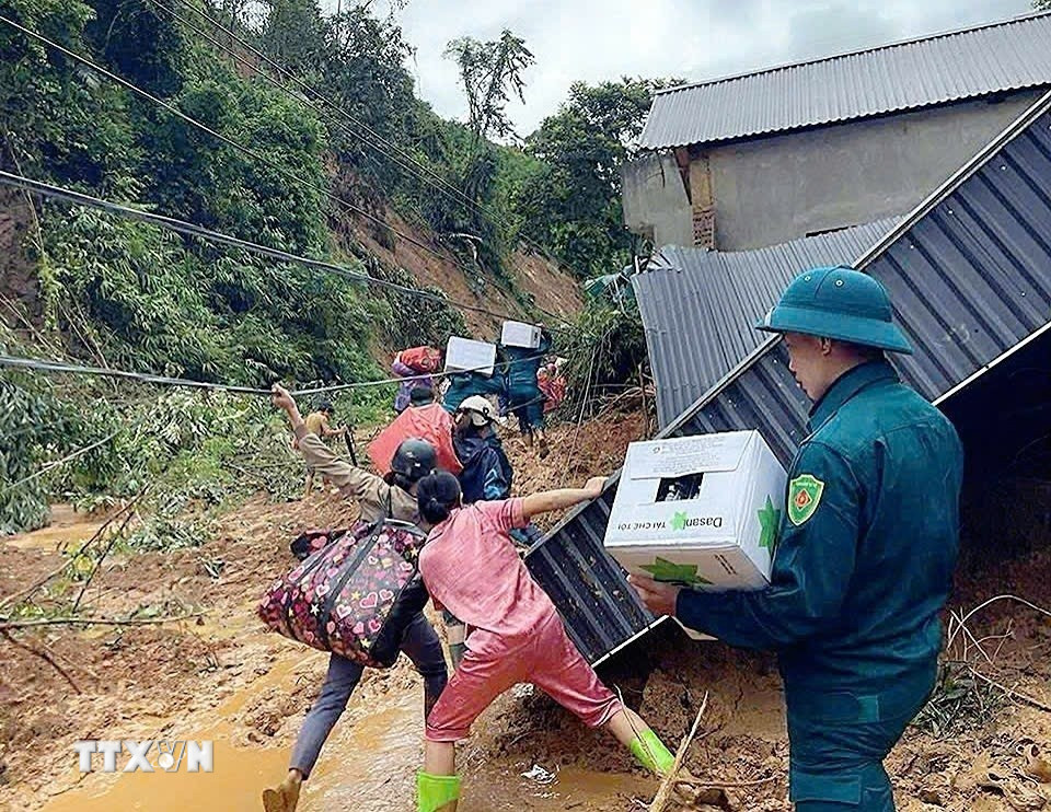 Các lực lượng và người dân cùng chung tay vận chuyển đồ vào điểm cô lập ở xã Yên Nhân. (Nguồn: TTXVN phát)