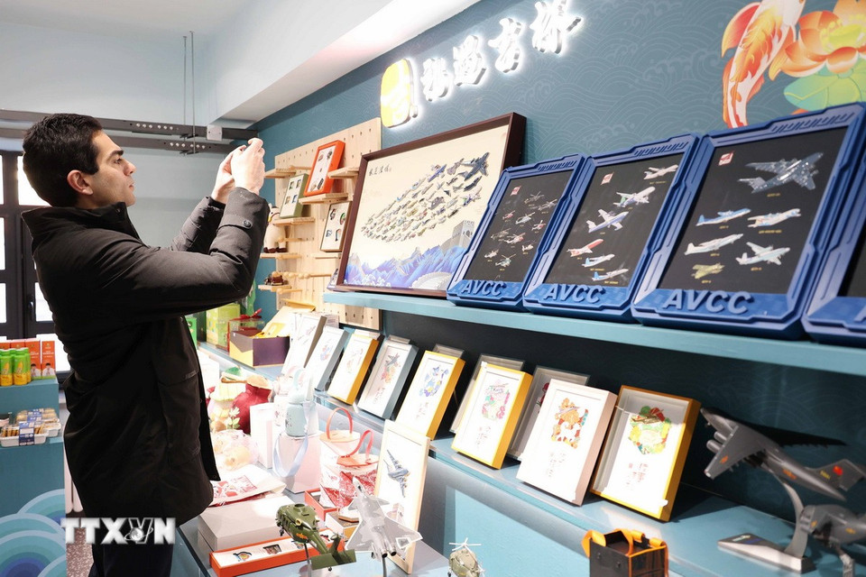 Du khách tìm hiểu về nghệ thuật chế tác tranh da cá của tỉnh Cát Lâm. (Ảnh: Công Tuyên/TTXVN)