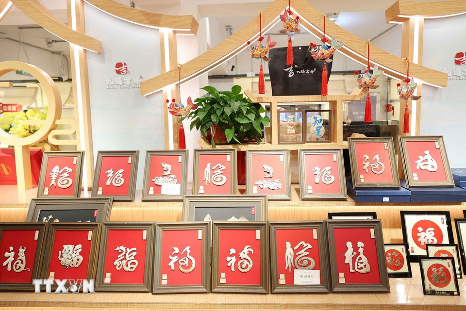 Tranh chữ Phúc được chế tác từ da cá hồ Tra Can với nhiều loại chữ khác nhau. (Ảnh: Công Tuyên/TTXVN)