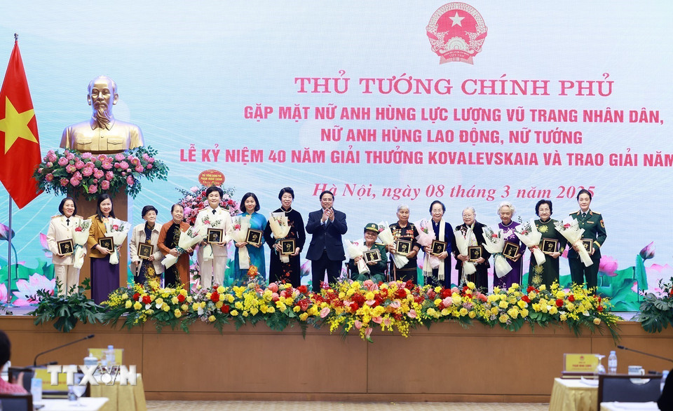 Thủ tướng Phạm Minh Chính tặng hoa chúc mừng các nữ Anh hùng lực lượng vũ trang nhân dân, nữ Anh hùng lao động, nữ tướng, nhà khoa học nữ. (Ảnh: Dương Giang/TTXVN)