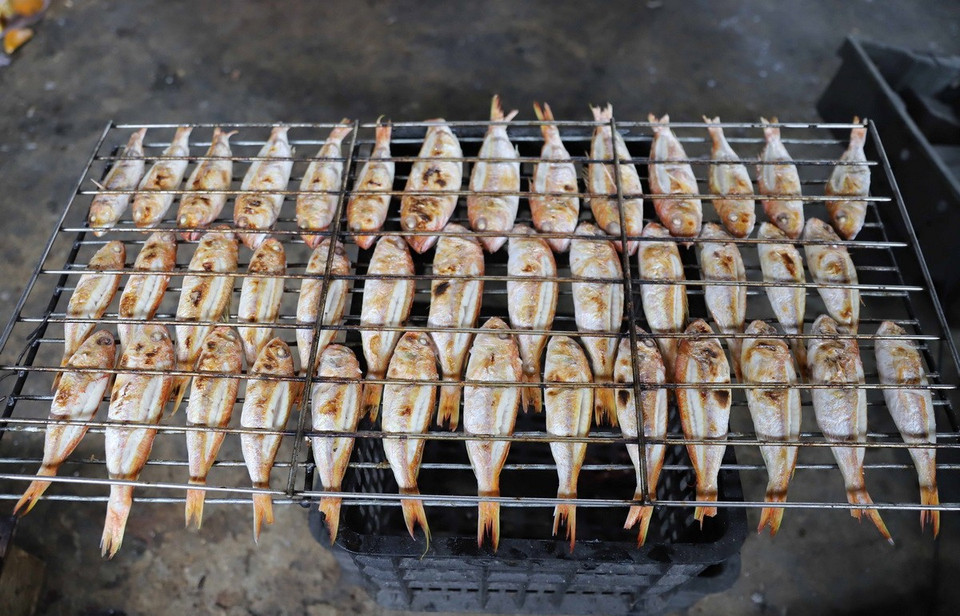 Cá biển khi nướng được kẹp bằng hai giàn nướng, thuận lợi cho việc đảo mặt. (Ảnh: Xuân Tiến/TTXVN)