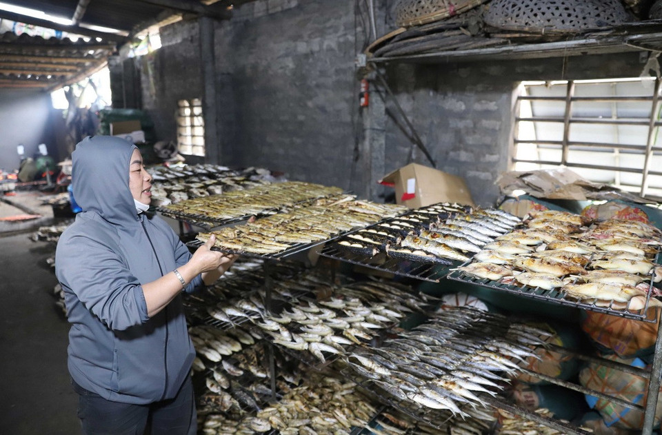 Xếp các giàn cá nướng đã chín lên khung. (Ảnh: Xuân Tiến/TTXVN)