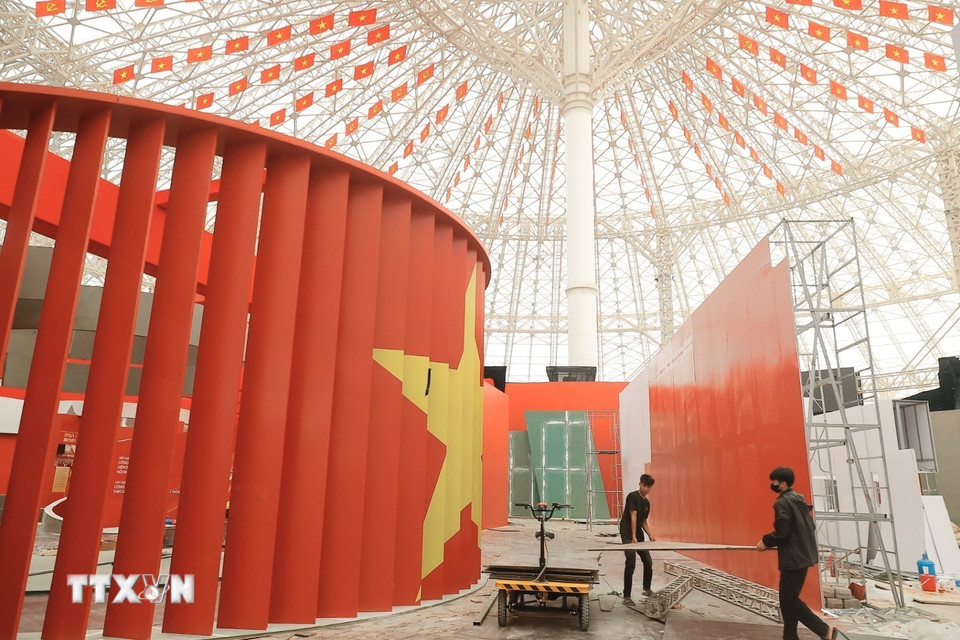 Công nhân hoàn thiện những hạng mục cuối, chuẩn bị cho khai mạc triển lãm. (Ảnh: Minh Quyết/TTXVN)