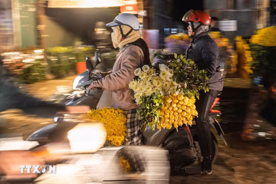 Hoa cúc, hoa hồng được mua, bán nhiều tại chợ hoa dịp Tết. (Ảnh: Hoàng Hiếu/TTXVN)