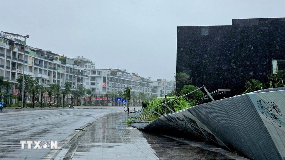 Hàng rào tôn trên đường Trần Quốc Nghiễn, cạnh Thư viện Quảng Ninh, bị bão làm nghiêng đổ. (Ảnh: Thanh Vân/TTXVN)