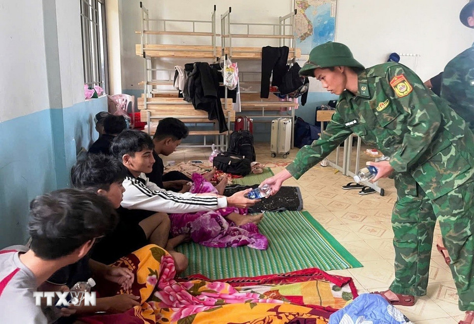 Cán bộ, chiến sỹ Đồn Biên phòng Roòn phối hợp với địa phương di dời người dân đến trường Tiểu học và trường THCS Quảng Đông tránh trú bão. (Nguồn: TTXVN phát)