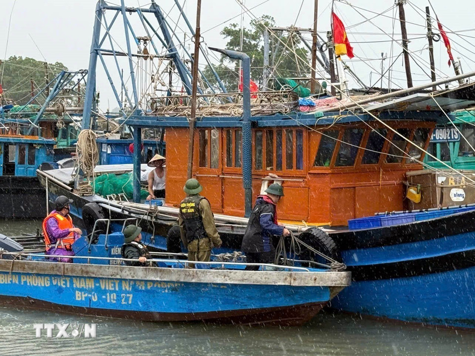 Chiến sỹ Bộ đội Biên phòng đồn Trà Cổ (Bộ đội Biên phòng Quảng Ninh) vận động ngư dân đưa thuyền và về nơi tránh trú an toàn. (Ảnh: Thanh Vân/TTXVN)