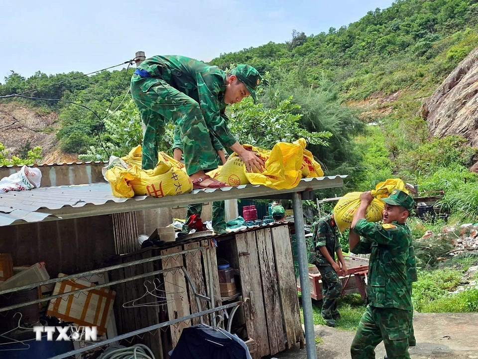 Chiến sỹ Bộ đội Biên phòng Đảo Trần (Bộ đội Biên phòng Quảng Ninh) giúp người dân chằng chống nhà cửa trước bão. (Ảnh: Thanh Vân/TTXVN)