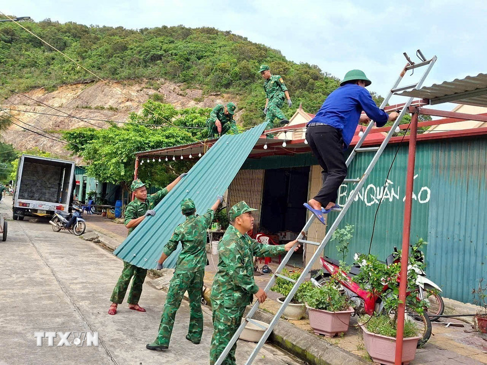 Chiến sỹ Bộ đội Biên phòng Đảo Trần (Bộ đội Biên phòng Quảng Ninh) giúp người dân chằng chống nhà cửa trước bão. (Ảnh: Thanh Vân/TTXVN)