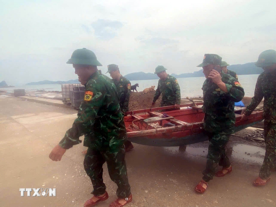 Chiến sỹ Bộ đội Biên phòng đồn Ngọc Vừng (Bộ đội Biên phòng Quảng Ninh) giúp người dân đưa tài sản về nơi an toàn. (Ảnh: Thanh Vân/TTXVN)