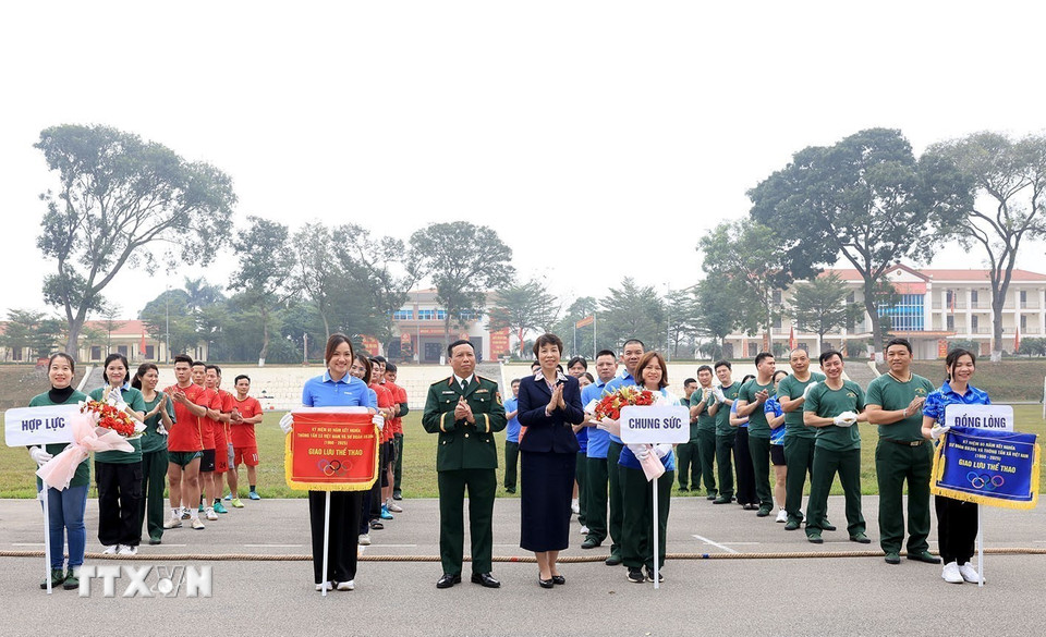 Đại diện lãnh đạo TTXVN và Sư doàn Bộ binh 304 tặng hoa cho các đội kéo co. (Ảnh: Tuấn Anh/TTXVN)