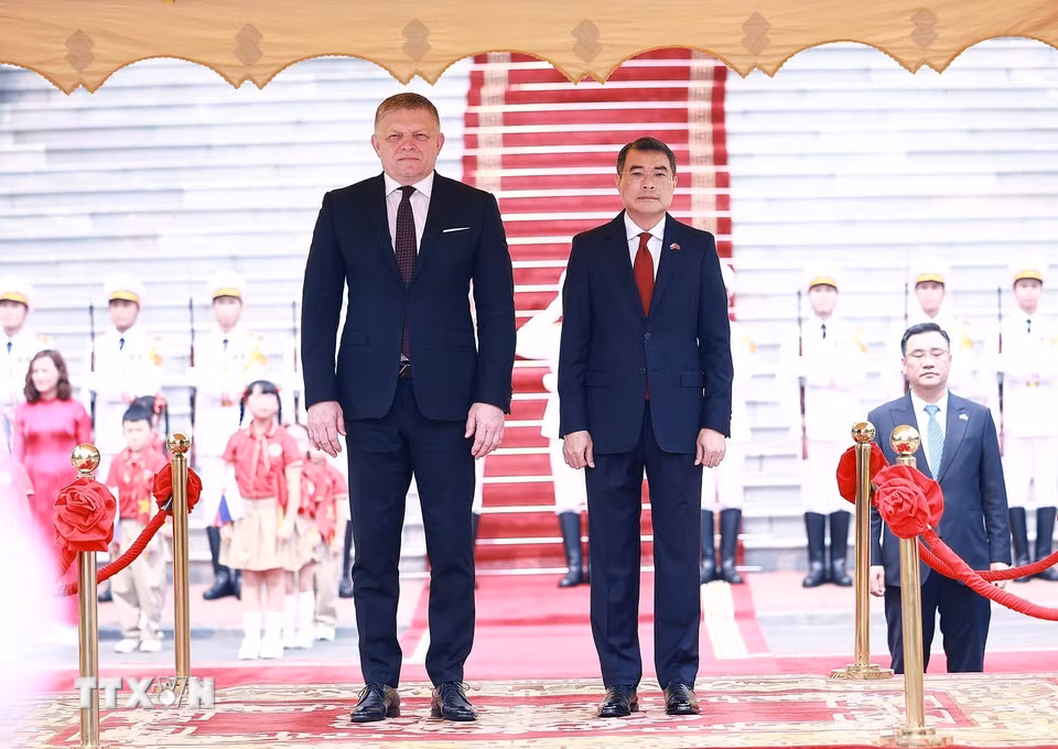 Thủ tướng Lê Minh Hưng và Thủ tướng Slovakia Robert Fico nghe Quân nhạc cử Quốc thiều hai nước. (Ảnh: Dương Giang/TTXVN)