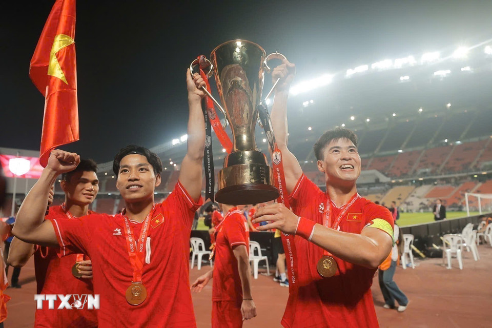 Duy Mạnh và Văn Thanh hân hoan giương cao cup vô địch trên sân Rajamangala, tối 5/1. (Ảnh: Minh Quyết/TTXVN)