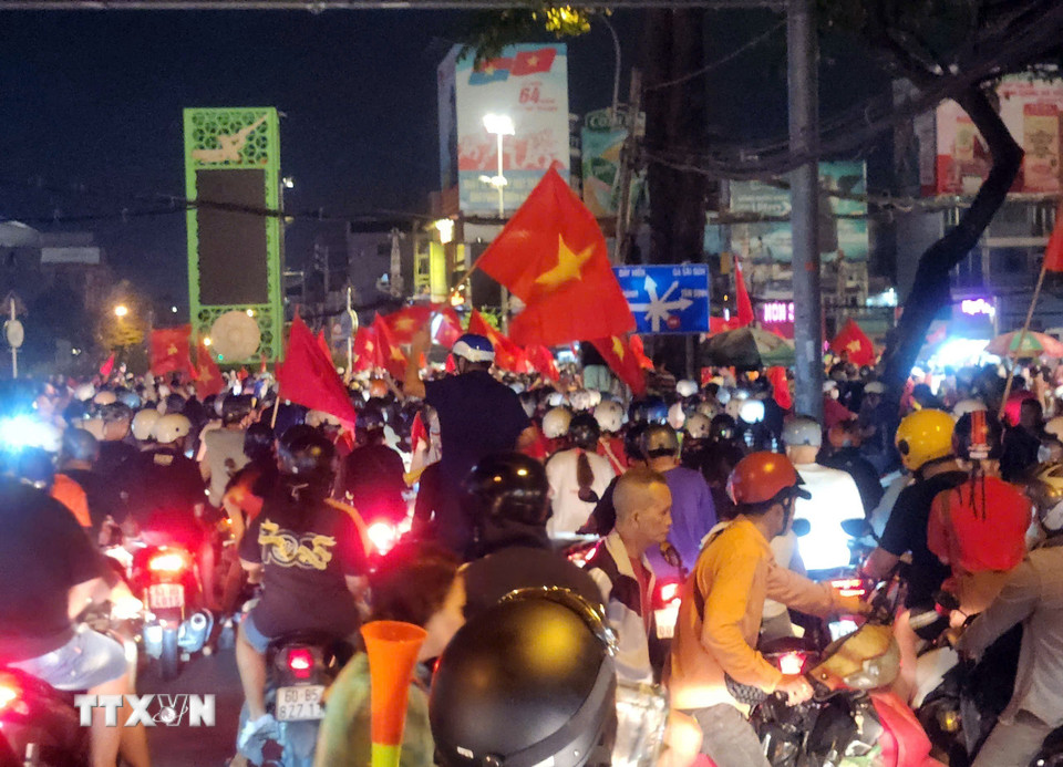 Các tuyến đường tại Thành phố Hồ Chí Minh rợp cờ đỏ sao vàng trong đêm 5/1/2025. (Ảnh: Mạnh Linh/TTXVN)