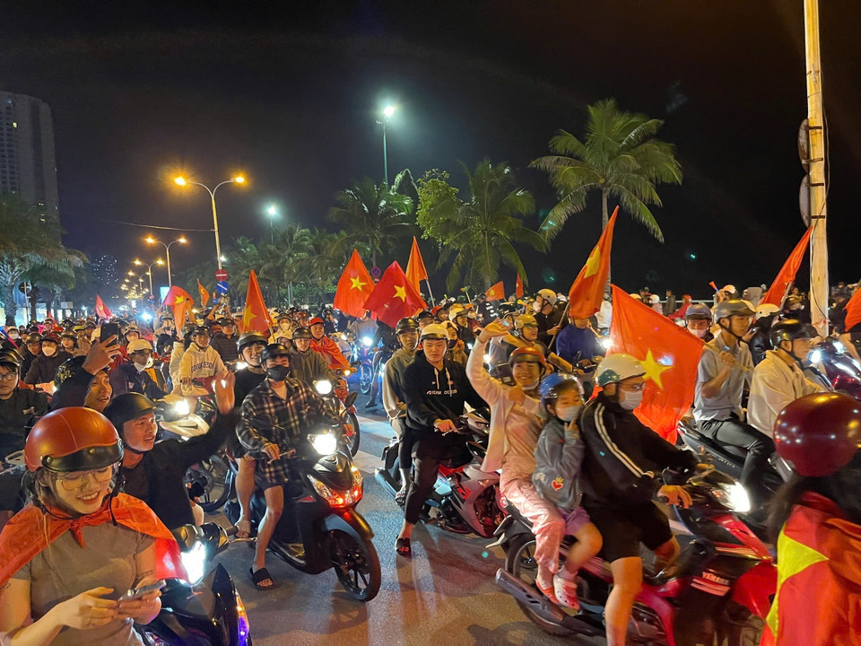 Tại thành phố Nha Trang, tỉnh Khánh Hòa, hàng trăm cổ động viên đã đổ ra đường, diễu hành qua nhiều tuyến phố lớn, tạo nên không khí lễ hội sôi động, ngập tràn sắc đỏ cờ hoa. Người dân hân hoan ăn mừng chiến thắng lịch sử của bóng đá Việt Nam. (Ảnh Đặng Tuấn/TTXVN)