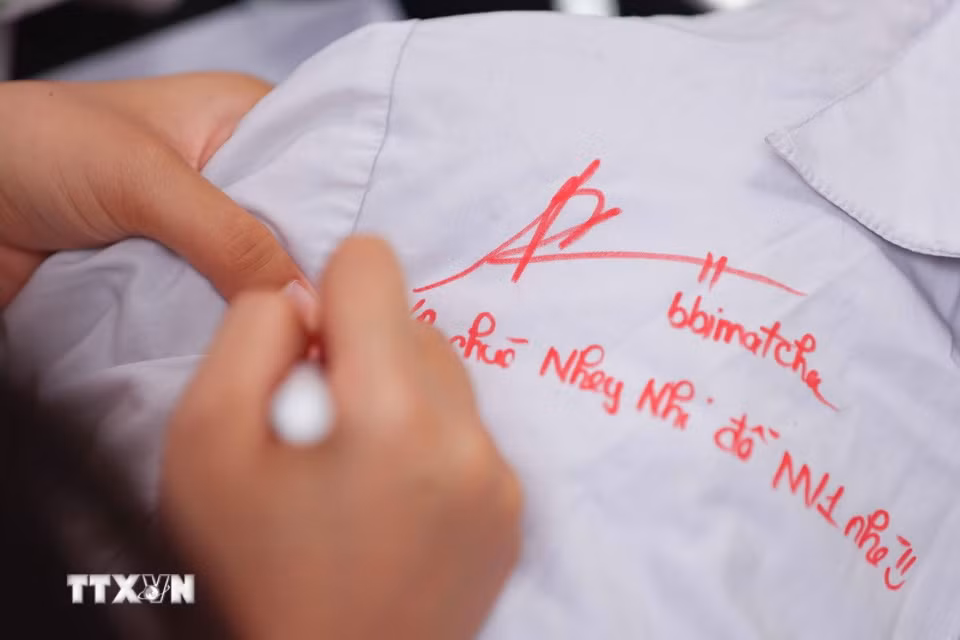 Những dòng lưu bút trên áo trắng học trò mãi là những kỷ niệm đẹp của một thời học sinh. (Ảnh: Thanh Tùng/TTXVN)