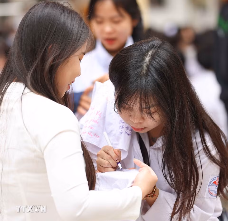 Những dòng lưu bút trên áo trắng học trò mãi là những kỷ niệm đẹp của một thời học sinh. (Ảnh: Thanh Tùng/TTXVN)