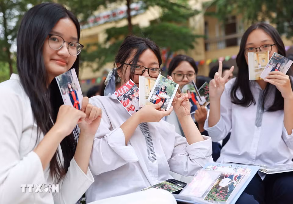 Cùng trao nhau những tấm ảnh chụp chung để ai cũng có một cuốn album luôn nhớ về nhau. (Ảnh: Thanh Tùng/TTXVN)
